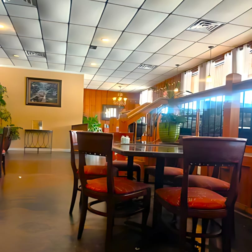 Interior of Ishy's Grill, an American restaurant, with tables, chairs, and warm lighting.